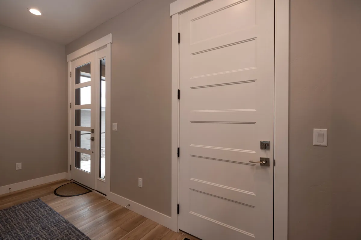 A welcoming entryway with a view of the front door, an interior door, and a cozy rug, all set in a bright, inviting space. This area serves as the threshold where guests and residents move from the excitement of outdoor adventures to the comfort of home.